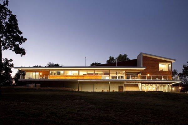 A large modern building with western red cedar siding at night