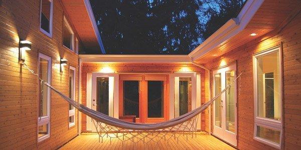 A modern house with cedar decking and a hammock hanging in the middle